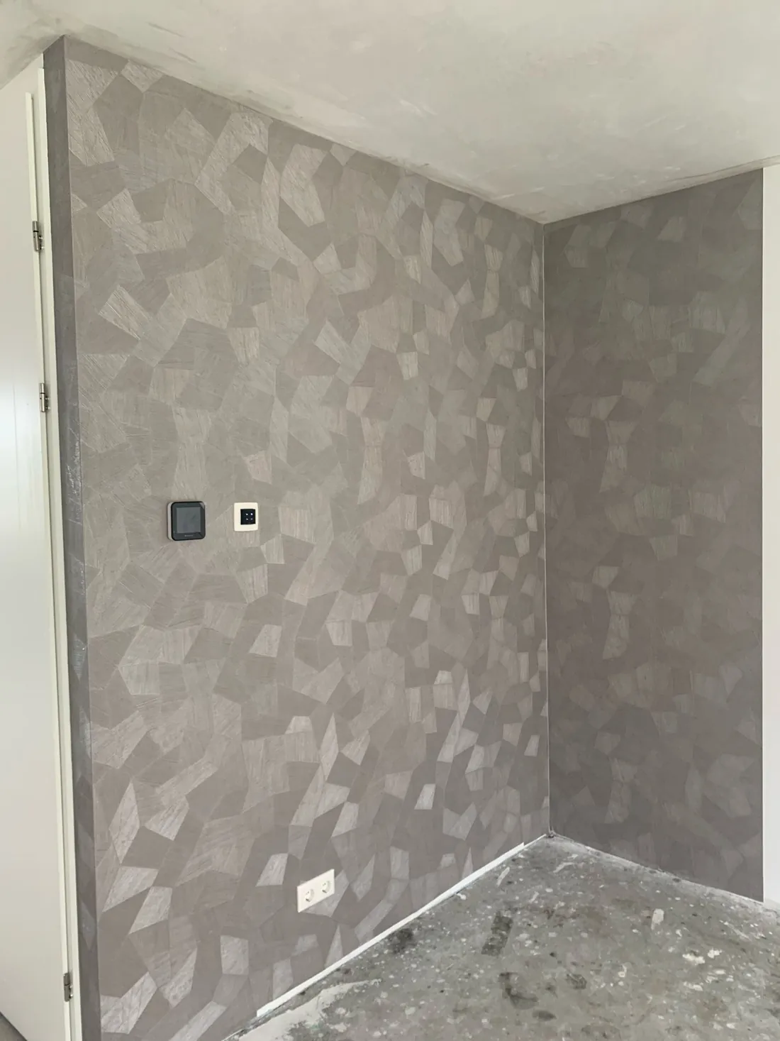 Grijs Arte-behang met geometrisch patroon om een binnenhoek