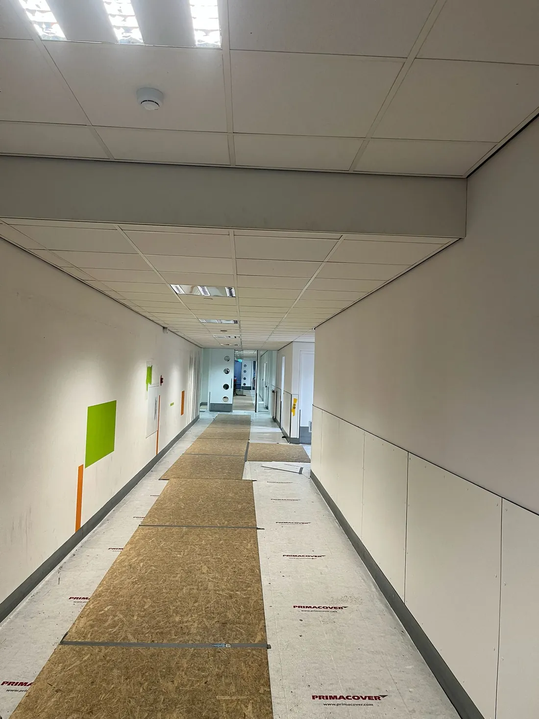Lange kantoorgang met strak afgewerkte wanden
